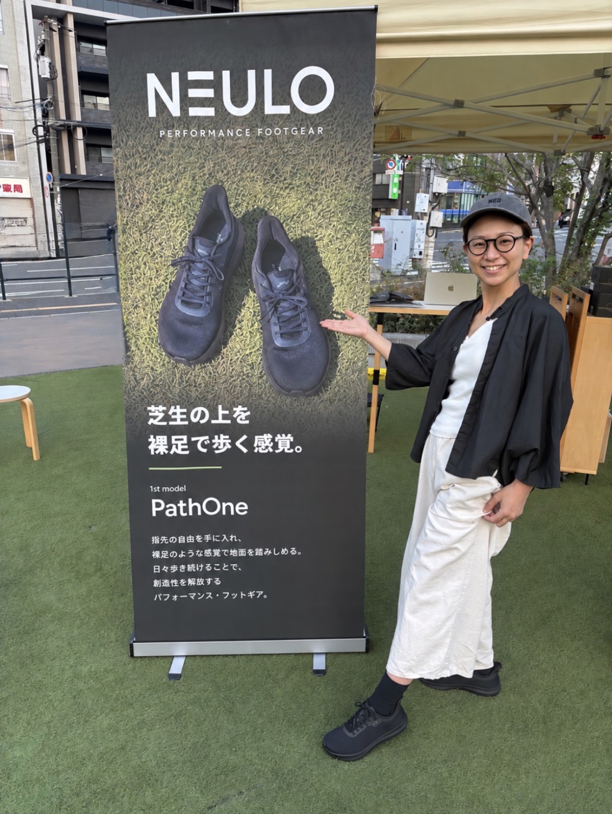 A customer wearing PathOne beside the NEULO banner